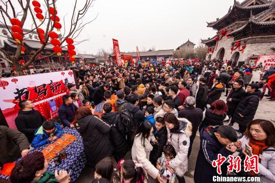 春节期间，河南建业大食堂吸引众多游客游庙会、吃小吃，拉动消费。　崔悦　摄