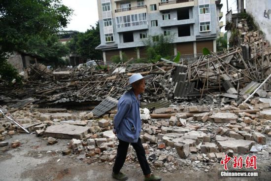 6月18日，四川省宜宾市长宁县双河镇老街，一位老人经过坍塌的房屋。6月17日22时55分，四川宜宾长宁县双河镇发生6.0级地震，震源深度16公里。