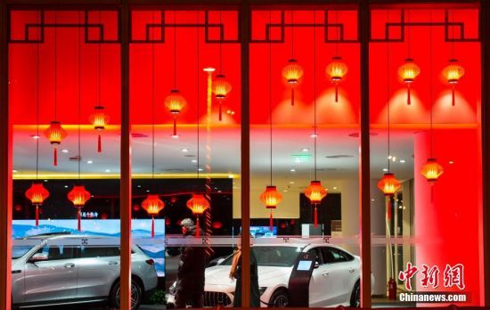 1月16日晚间，市民在北京一家汽车经销商门店内关注新车。春节临近，北京年味渐浓。中新社记者