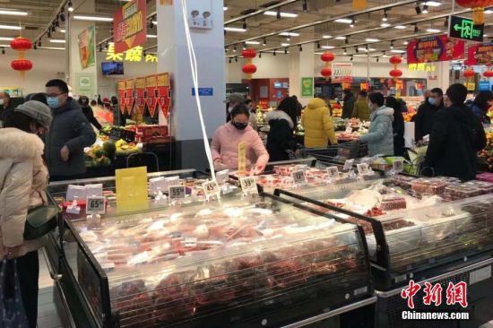1月23日，武汉市民佩戴口罩，在超市购买生活用品等物资。中新社记者