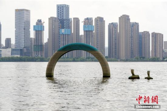 8月9日，汉口江滩“一家三口”雕塑部分露出江面。