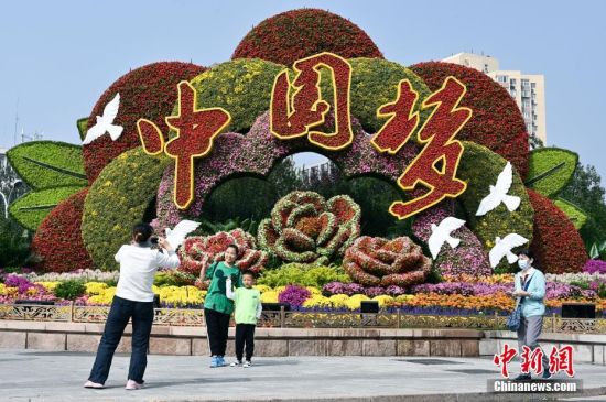 9月26日，市民在北京复兴门桥东北角《复兴伟业》国庆主题花坛前拍照。