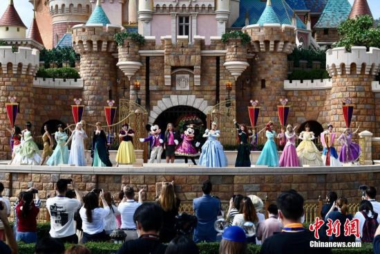 图为香港迪士尼乐园度假区行政总裁杨善妮在城堡舞台上与米奇米妮、13个迪士尼公主及女王故事角色一起庆祝。