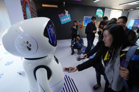 资料图片：10月31日，在北京海淀公园内的“未来空间”，人们与智能机器人交流。（新华社）