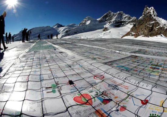 瑞士阿莱奇冰川展示的巨型明信片由12万多张小卡片组成1.5摄氏度等字样。