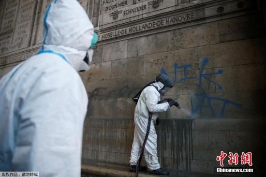 资料图：法国工作人员在修复被抗议者涂在凯旋门外墙上的涂鸦。