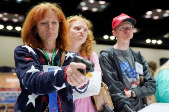 　　2019年4月28日，在美国印第安纳州首府印第安纳波利斯，参观者在美国全国步枪协会年会展览活动上体验手枪。(新华社/路透)