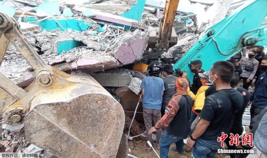 当地时间15日凌晨，印尼苏拉威西岛发生6.2级地震。目前，地震已造成至少42人死亡，数百人受伤，上千人流离失所。地震致震中所在的马杰内县和相距几十公里的西苏拉威西省首府马穆朱，灾情严重。包括省政府办公大楼、医院、酒店等在内的建筑在地震中严重损毁，大量民房倒塌。图为救援人员在马穆朱一座倒塌的建筑物内搜寻幸存者。