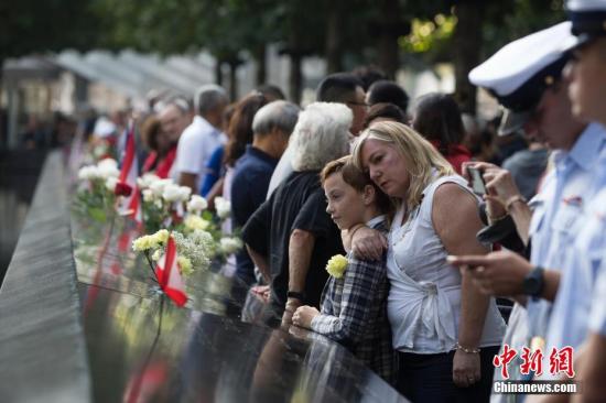 当地时间9月11日，民众在纽约世贸遗址前寄哀思。当日，美国“9·11”恐怖袭击事件18周年纪念活动在纽约“9·11”遗址纪念广场举行。