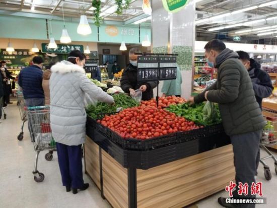 　　资料图：1月26日，农历大年初二，武汉超市内各种新鲜蔬菜供应充足，市民戴口罩选购。中新社记者